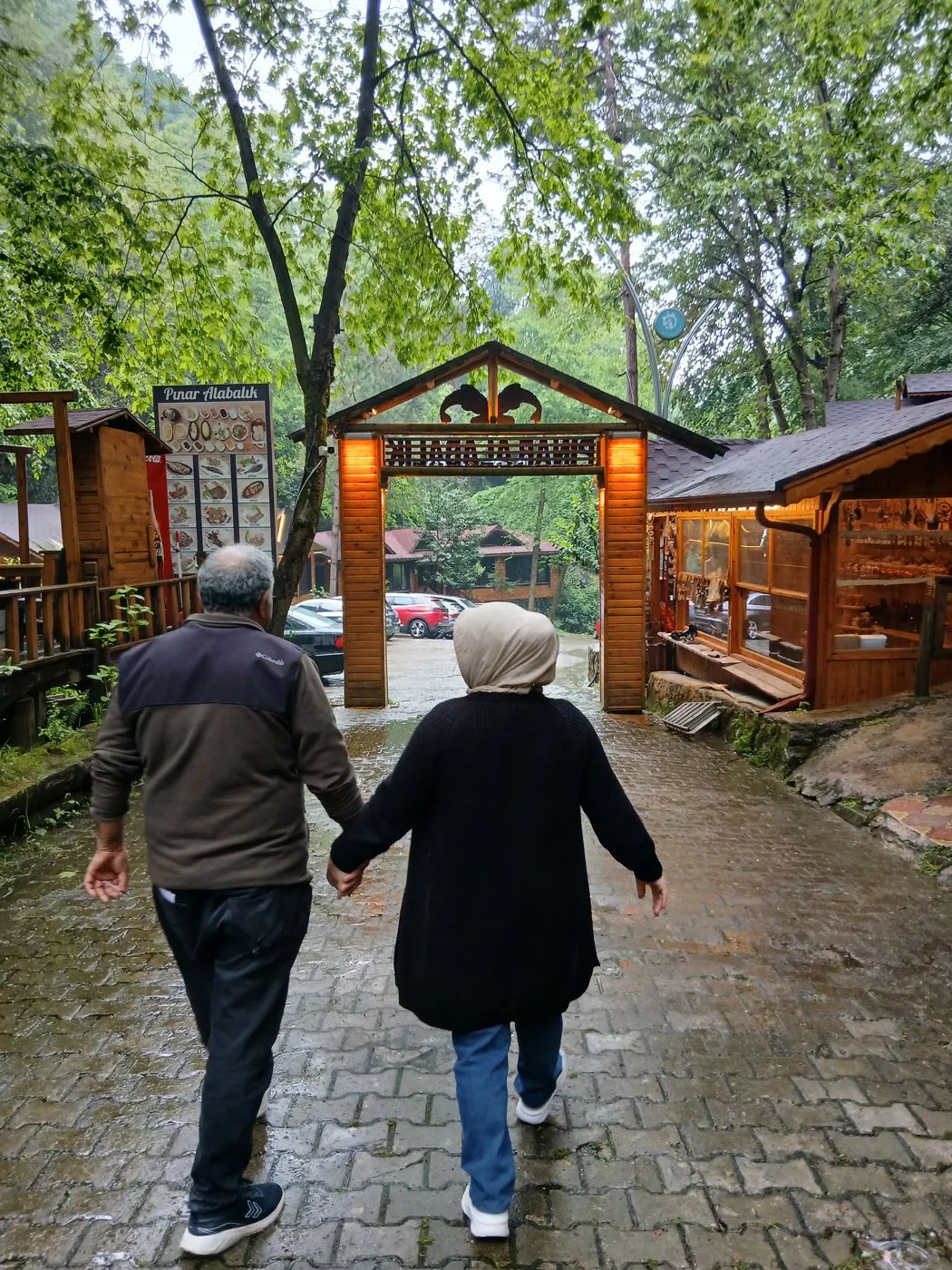 Yağmurdan sonra ıslak taş yolda el ele yürüyen annemle babam