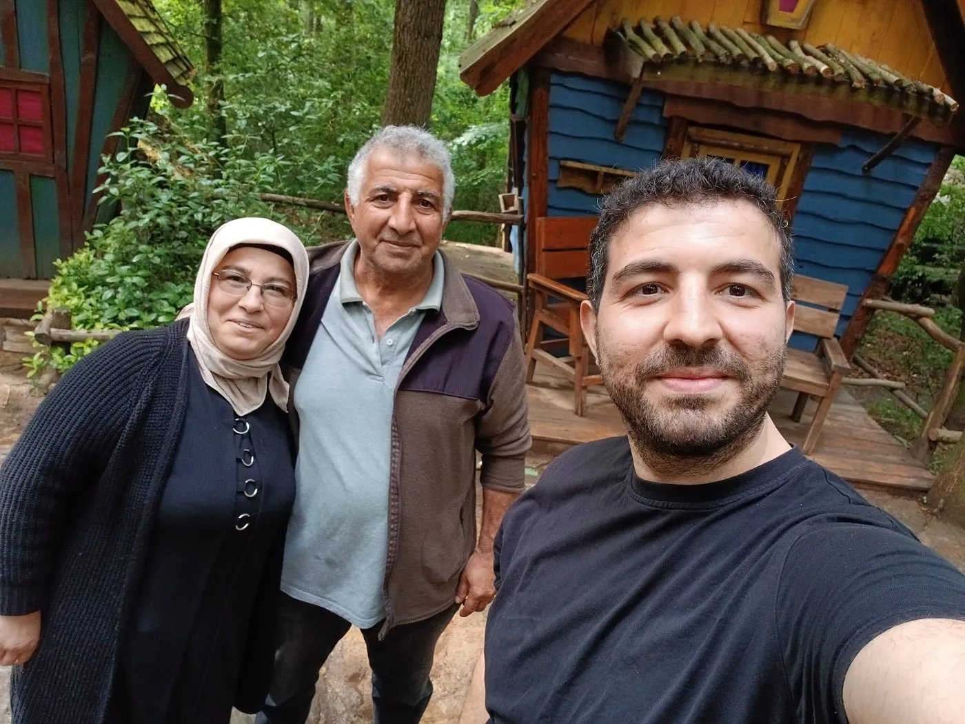 Ormandaki renkli kulübelerin önünde annem, babam ve ben