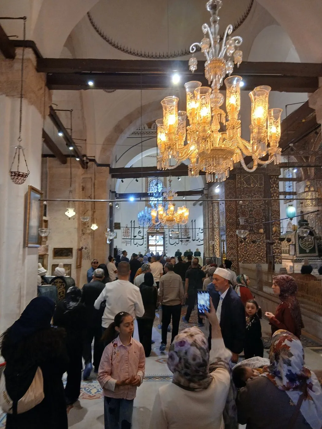 Mevlana’nın avizeli iç mekânı ve ziyaretçi kalabalığı