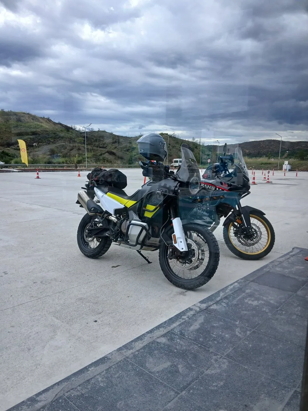 Sabah molasında park edilmiş iki motosiklet, bulutlu bir gökyüzü altında