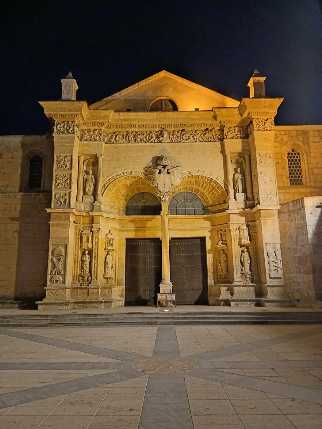 Gece ışıklandırılmış Catedral Primada de América’nın taş cephesi